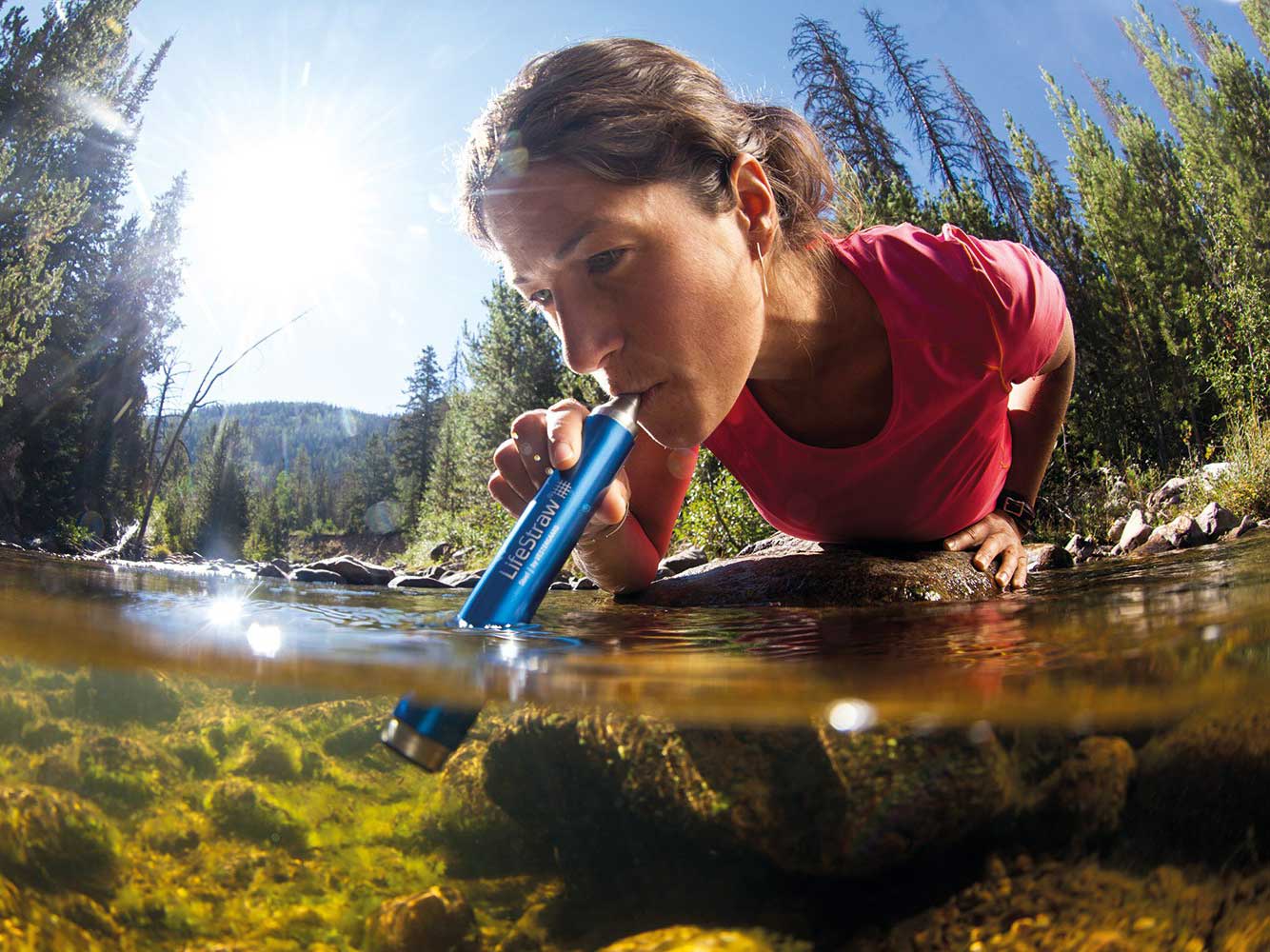 一位妇女用生命吸管喝河里的水