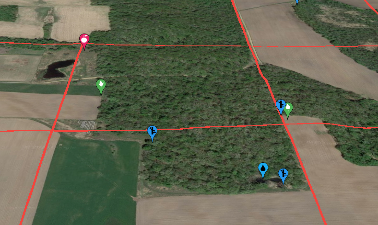 农田和木材的卫星图像，带有路标点和红色属性线网格。