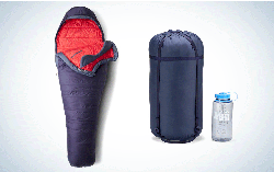 一个紫色和红色的睡袋紧挨着它的填充袋，还有一个水战