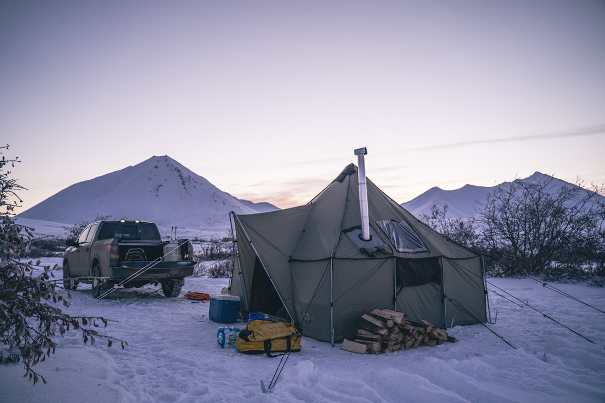 一个高大的帐篷与烟囱反对山日落